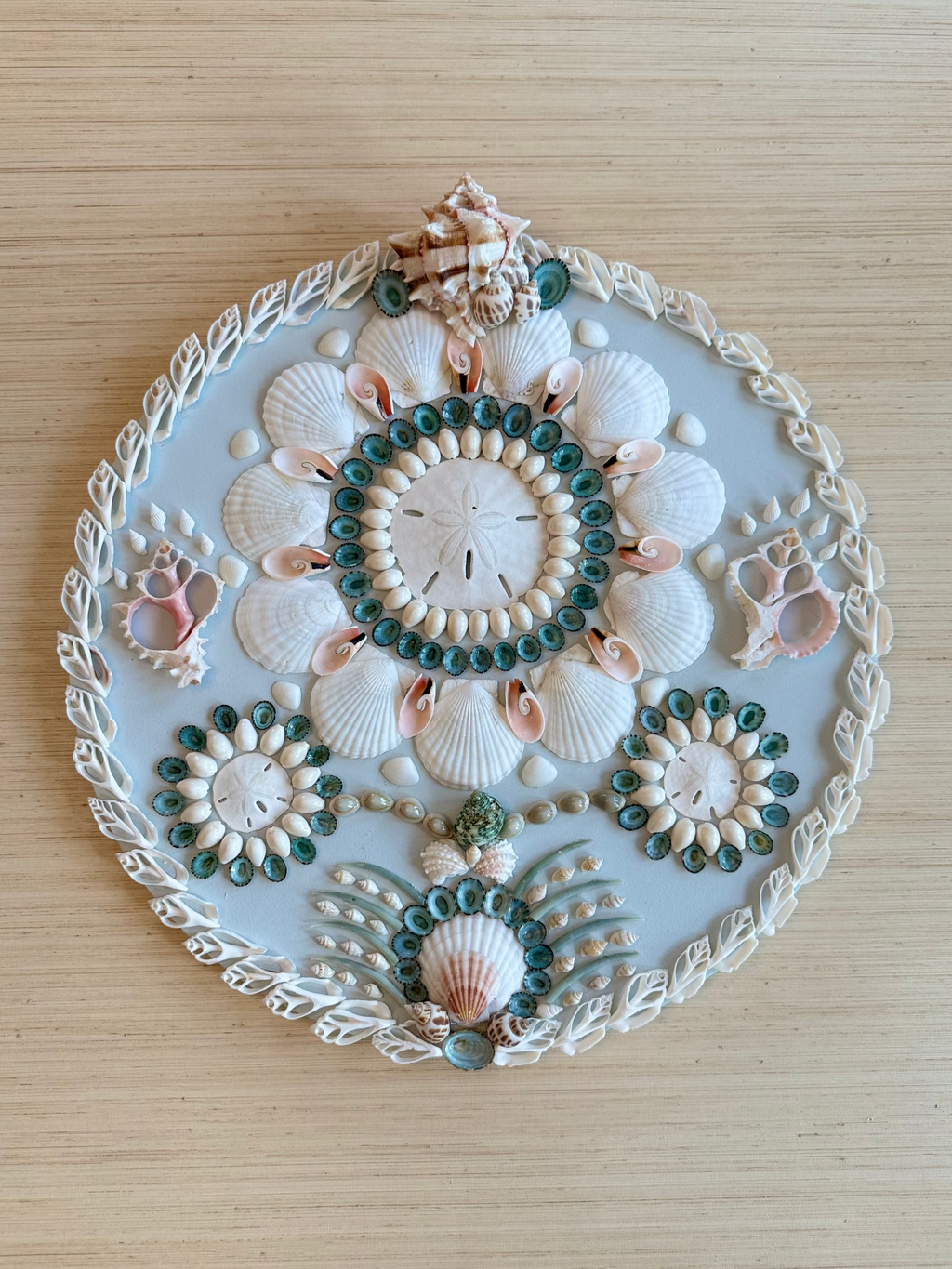 Serenely circular shell panel with seafoam and aqua seashells in concentric ring pattern, 18 inch diameter coastal wall art